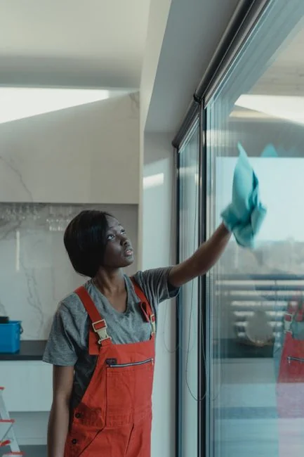 High-rise window washers in safety gear cleaning a skyscraper facade.